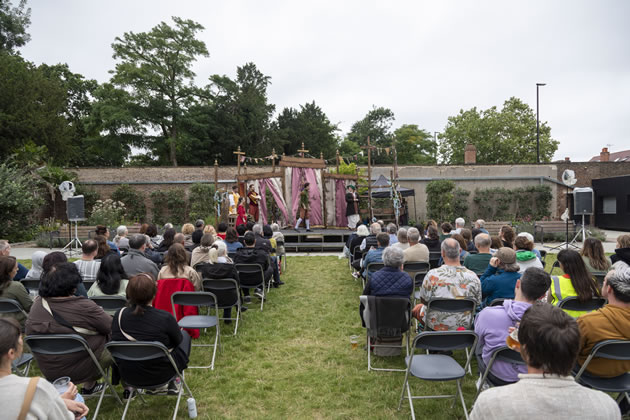 The audience enjoys a play in the walled garden last year