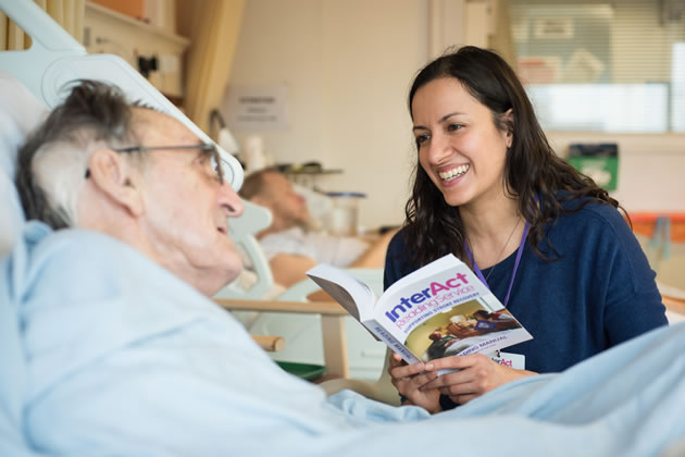 An actor reads to a stroke patient as part of the Interact scheme 